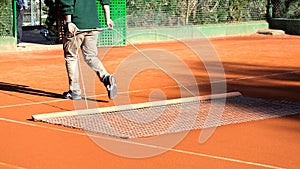 Cleaning the lines on a clay tennis court