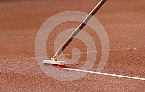 Cleaning the marking line of the clay tennis court