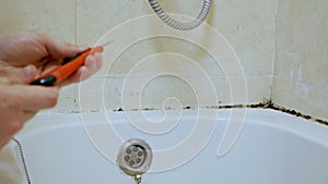 Cleaning mold and rust grow in tile joints in a humid, poorly ventilated bathroom with high humidity, weight, moisture