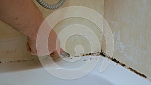 Cleaning mold and rust grow in tile joints in a humid, poorly ventilated bathroom with high humidity, weight, moisture