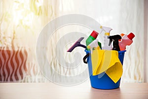 Cleaning products in bucket: bottles, sprays, gloves etc,