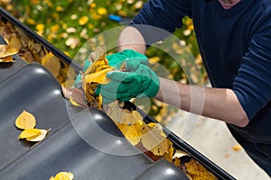 Cleaning the rain gutter during autumn photo