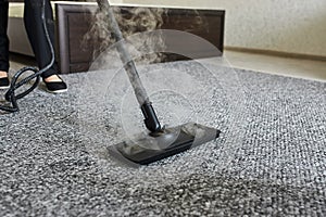 Cleaning service company employee removing dirt from carpet in flat with professional steam cleaner equipment close up
