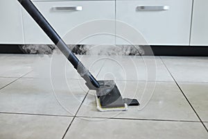 Cleaning service company employee removing dirt from carpet in flat with professional steam cleaner equipment close up