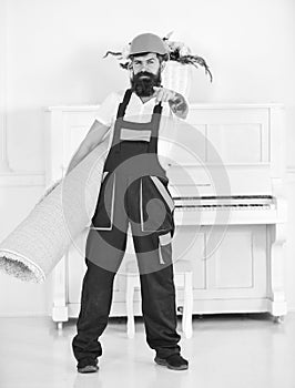 Cleaning service concept. Courier delivers furniture in case of move out, relocation. Man with beard, worker in overalls