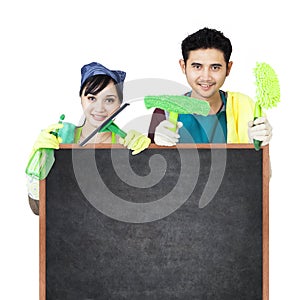 Cleaning service couple holding blackboard photo
