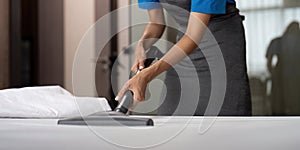 Cleaning service employee removing dirt from with professional equipment. Female housekeeper cleaning the mattress on