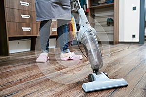 Cleaning service. the female cleaner vacuums the floor with a vacuum cleaner