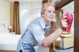 Cleaning service. hotel staff clean glass door from dust