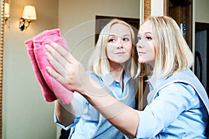 Cleaning service. hotel staff clean mirror