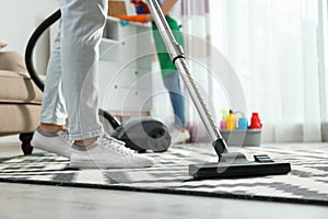 Cleaning service professional vacuuming carpet indoors photo