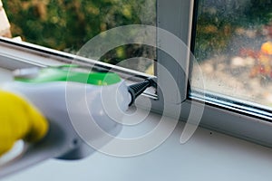 Cleaning service to clean the window frame from dirt with a steam device