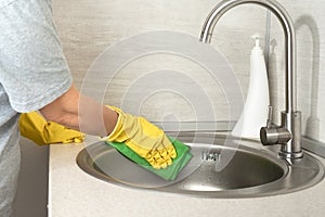 Cleaning service. woman gloves hands cleaning kitchen sink. Cleaning home table, sanitizing kitchen table, surface with