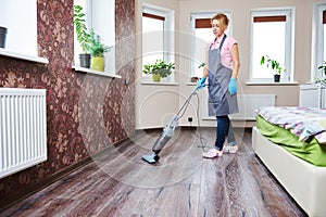 Cleaning service. woman vacuum floor in room