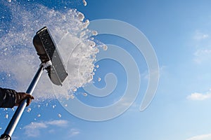 Cleaning snow shovel, throwing snow