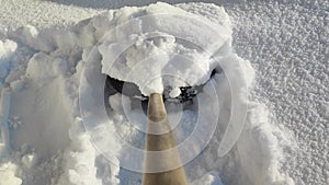 Cleaning snowdrifts near the house with a snow shovel