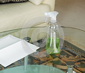 Cleaning Solution Spray Bottle on Top of Dirty Glass Table