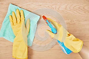Cleaning spray, glove hands and wipe table, counter and wood surface for housekeeping service at home. Above of maid