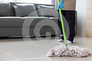 Cleaning staff is wiping cloth with cleaner and disinfectant on the surface of floor to make the floor clean with cleaning