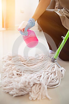Cleaning staff is wiping cloth with cleaner and disinfectant on the surface of floor to make the floor clean with cleaning