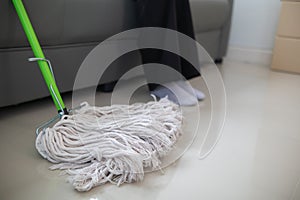 Cleaning staff is wiping cloth with cleaner and disinfectant on the surface of floor to make the floor clean with cleaning