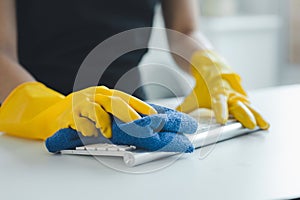 Cleaning staff wiping down office equipment, Wipe the keyboard clean with a towel and disinfectant. Wear rubber gloves when