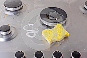 Cleaning of stainless steel gas stove with scrub and sponge