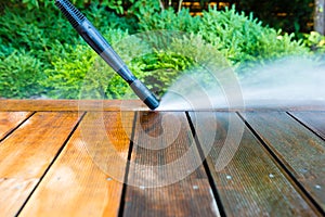 Cleaning terrace with a power washer - high water pressure cleaner on  terrace surface