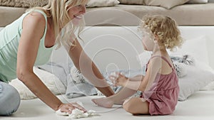 Cleaning and tidying up the house, the mother cheerfully teaches her daughter child how to clean the floor of living room, empower
