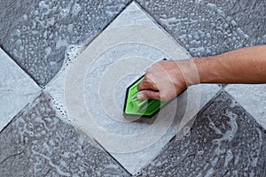 Cleaning the tiled floor with a plastic floor scrubber