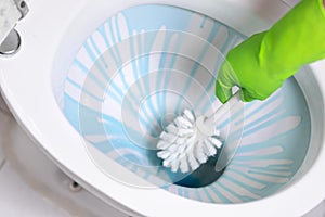 Cleaning toilet bowl using brush and detergent