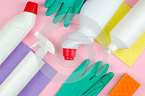 Cleaning tools company concept. White bottles with detergents and cleaning products and a sponge on a rose background