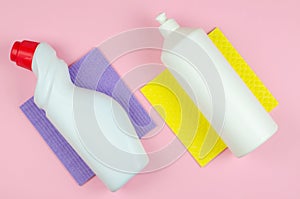 Cleaning tools company concept. White bottles with detergents and cleaning products and a sponge on a colored background