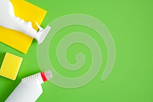 Cleaning tools and supplies on green background. House cleaning service and housekeeping concept. Flat lay, top view