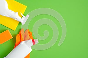 Cleaning tools and supplies on green background. House cleaning service and housekeeping concept. Flat lay, top view
