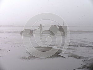 Cleaning tractor in foggy weather on the beach of Sainte CÃ©cile Plage in Picardie photo