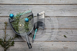 Cleaning up after christmas. Sweeping up pine needles and broken decorations