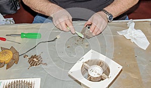 Cleaning a very dirty kitchen exhaust fan from dirt with a brush. A man cleans the parts of a fan with a brush