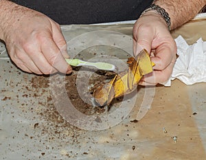 Cleaning a very dirty kitchen exhaust fan from dirt with a brush. A man cleans the parts of a fan with a brush