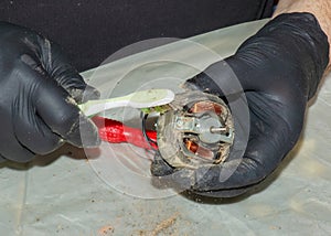 Cleaning a very dirty kitchen exhaust fan from dirt with a brush. A man cleans the parts of a fan with a brush