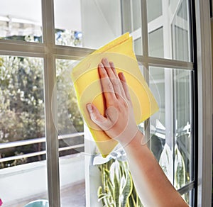 cleaning a window with yellow cloth