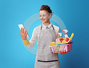 Cleaning woman with a basket with cleansers and brushes