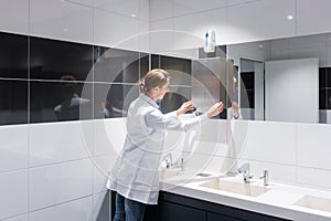 Cleaning woman refilling paper towels in public toilet