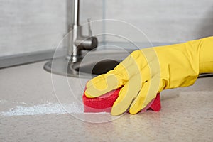 Deep Cleaning service. woman yellow gloves hands cleaning kitchen table with red sponge. Surface sanitizing. Home cleaning and