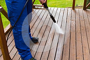 Cleaning wooden terrace with high pressure washer photo