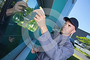 Cleaning worker cleaning windows outdoors building office