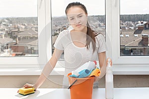 Cleanliness and hygiene in the house. Young girl with cleaning products for the bathroom, sink, toilet, sponge and rags