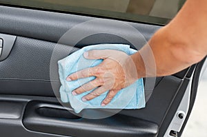 Cleansing car interior and door. Male hand  disinfecting vihicle