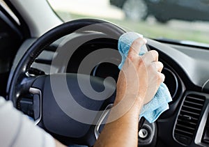 Cleansing car interior and wheel. Male hand  disinfecting vihicle inside