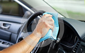 Cleansing car interior and wheel. Male hand  disinfecting vihicle inside